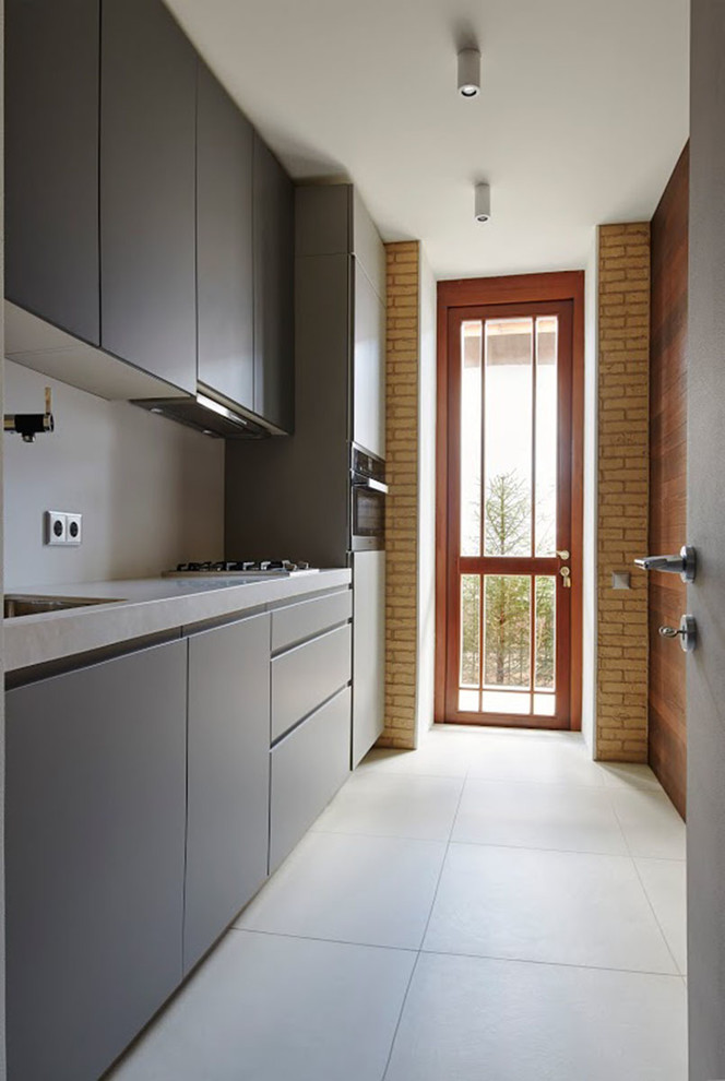 Идея дизайна: отдельная, прямая кухня в современном стиле с врезной мойкой, плоскими фасадами, серыми фасадами, техникой из нержавеющей стали и белым полом
