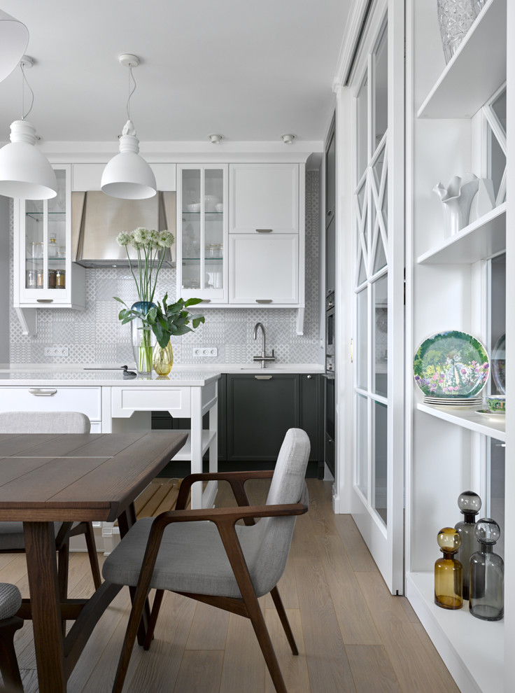 Inspiration för ett vintage kök och matrum, med luckor med infälld panel, vita skåp, grått stänkskydd, mellanmörkt trägolv, en köksö och brunt golv