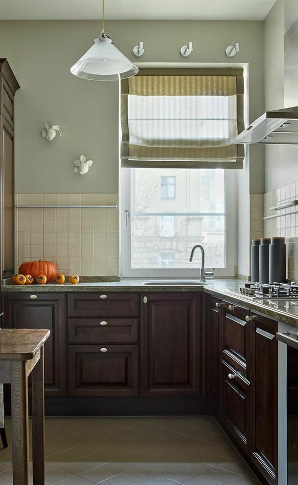 Klassische Küche in L-Form mit profilierten Schrankfronten, dunklen Holzschränken, Waschbecken, Küchenrückwand in Weiß, grauem Boden und Rückwand-Fenster in Moskau