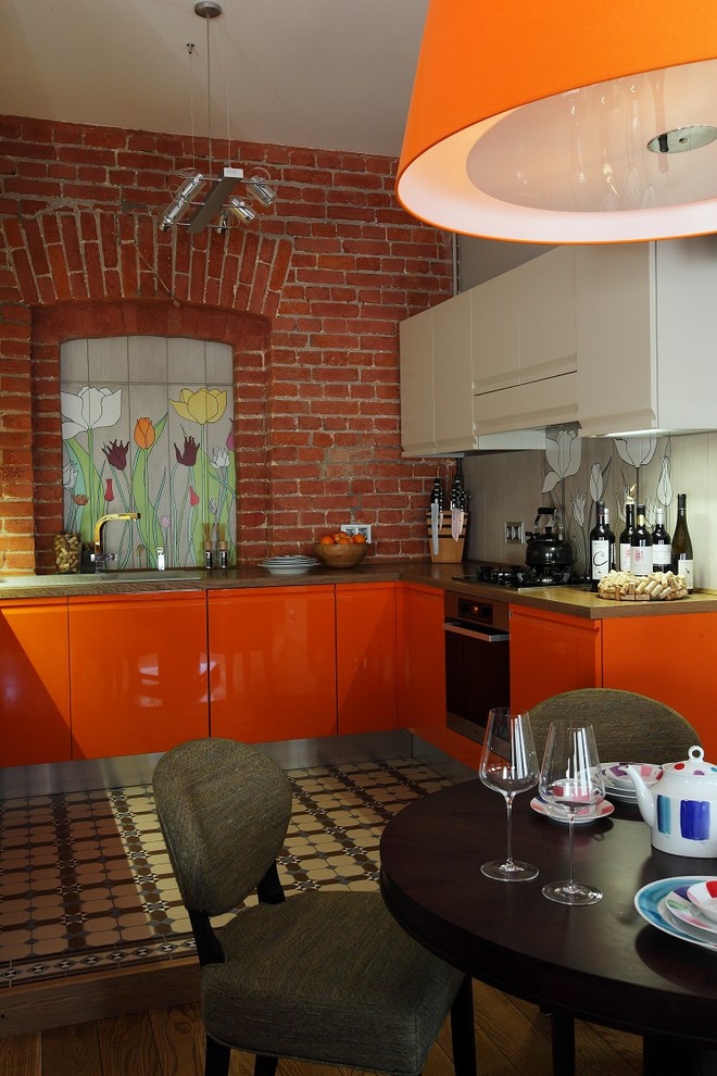 Cette photo montre une cuisine industrielle avec des portes de placard oranges.