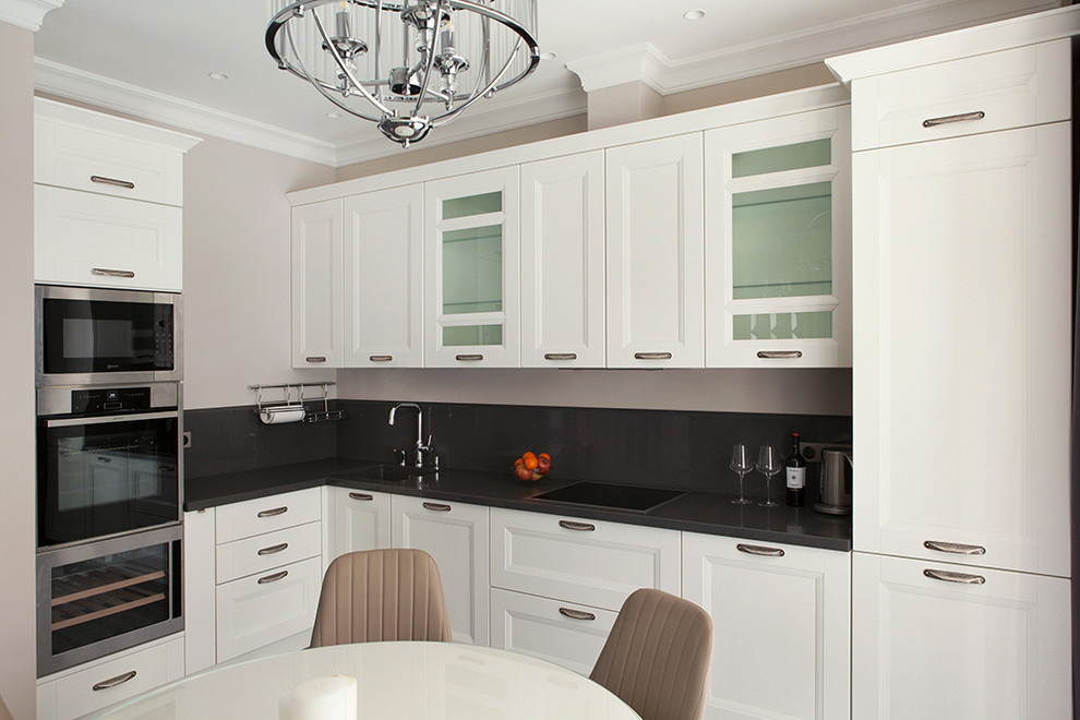 Classic l-shaped kitchen/diner in Moscow with recessed-panel cabinets, white cabinets, black splashback, stainless steel appliances, black worktops, a single-bowl sink and no island.