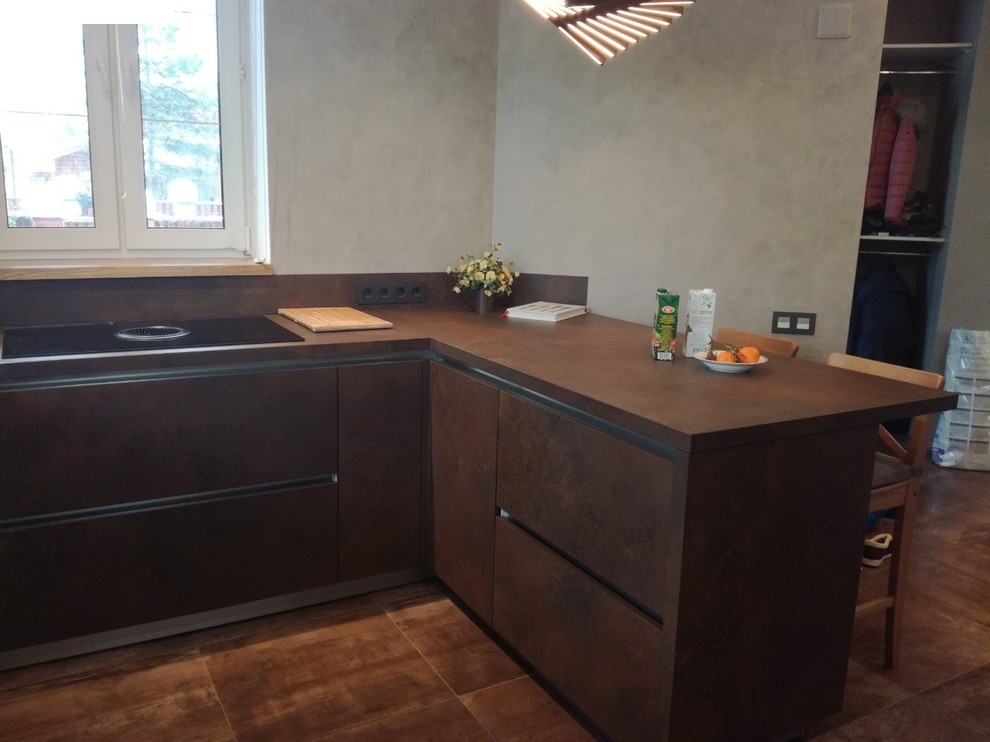 This is an example of a large industrial u-shaped kitchen/diner in Saint Petersburg with a submerged sink, flat-panel cabinets, brown cabinets, black appliances, porcelain flooring, a breakfast bar, brown floors and brown worktops.