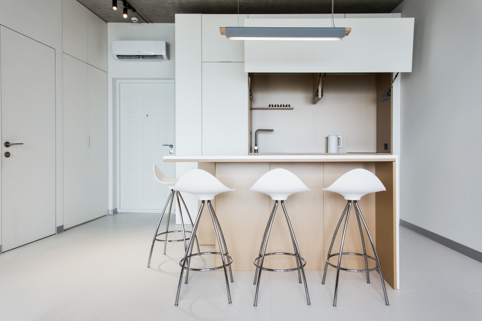 Esempio di una cucina minimal di medie dimensioni con ante lisce, ante bianche, paraspruzzi beige, elettrodomestici da incasso, pavimento in gres porcellanato, pavimento bianco e top bianco
