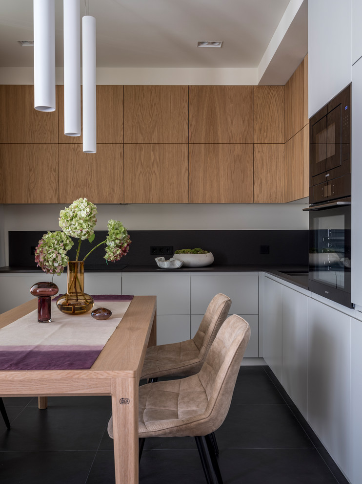 Idee per una cucina lineare design con ante lisce, ante in legno scuro, paraspruzzi nero, pavimento nero e top nero
