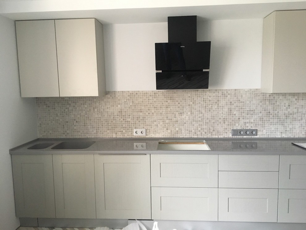 Inspiration for a large classic galley kitchen/diner in Moscow with an integrated sink, raised-panel cabinets, grey cabinets, composite countertops, multi-coloured splashback, mosaic tiled splashback, black appliances, an island and grey worktops.