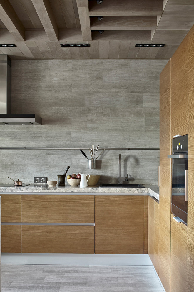 Contemporary l-shaped kitchen in Moscow with a built-in sink, flat-panel cabinets, medium wood cabinets, grey splashback, black appliances, grey floors, grey worktops and ceramic flooring.