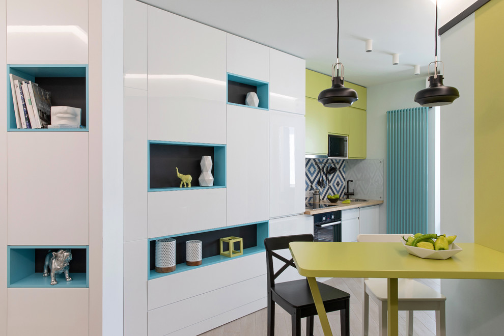 Inspiration for a small contemporary single-wall open plan kitchen in Other with a single-bowl sink, flat-panel cabinets, green cabinets, wood worktops, multi-coloured splashback, ceramic splashback, stainless steel appliances, laminate floors, an island, beige floors and green worktops.