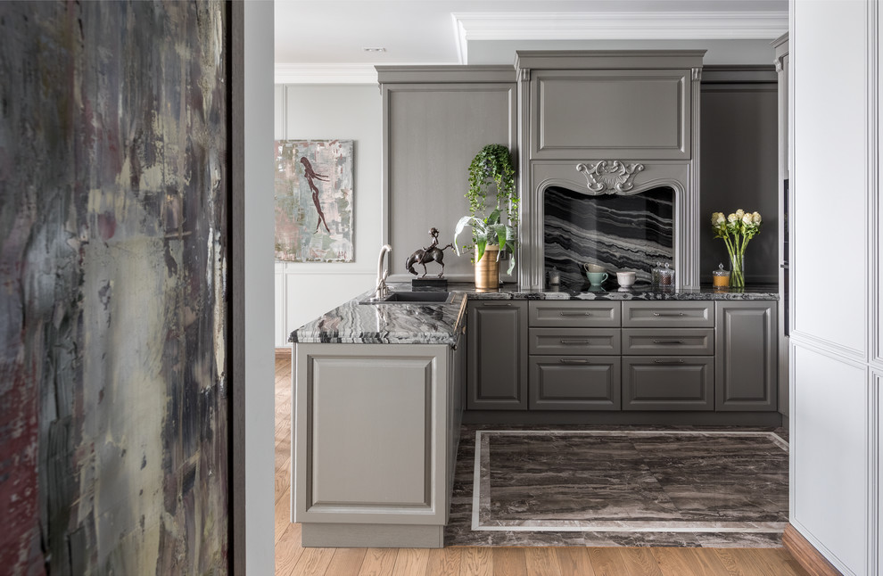 This is an example of a traditional u-shaped kitchen with a built-in sink, raised-panel cabinets, grey cabinets, grey splashback, a breakfast bar, grey floors, grey worktops, marble worktops and marble flooring.