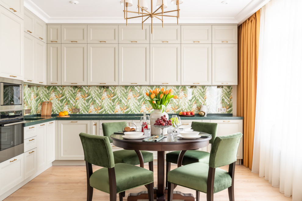 Inredning av ett klassiskt grön grönt kök, med luckor med infälld panel, beige skåp, flerfärgad stänkskydd, rostfria vitvaror, ljust trägolv och beiget golv