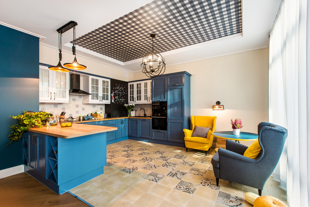 Exempel på ett stort klassiskt kök, med luckor med glaspanel, blå skåp, träbänkskiva, flerfärgad stänkskydd, svarta vitvaror och en halv köksö