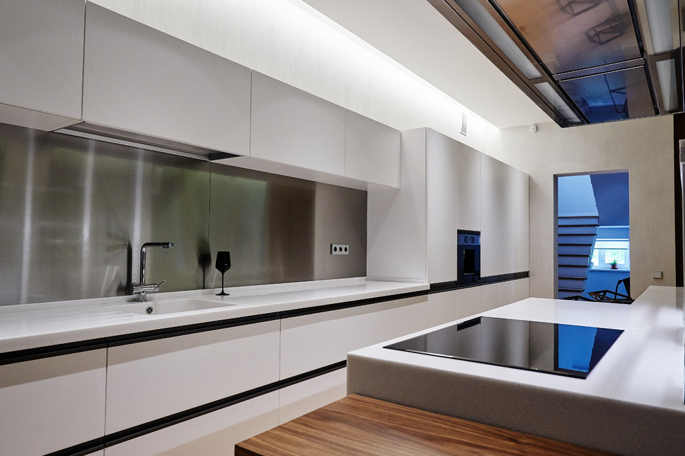 Foto de cocina lineal actual de tamaño medio abierta con armarios con paneles lisos, puertas de armario blancas, salpicadero metalizado, una isla y encimeras blancas