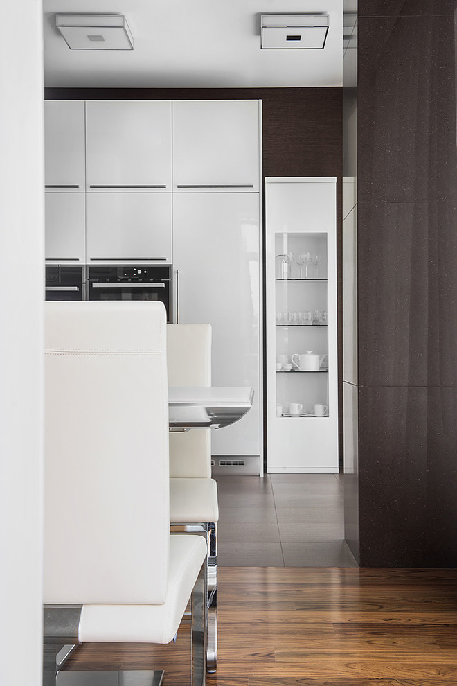 Idee per una cucina contemporanea di medie dimensioni con ante lisce, ante bianche, pavimento in gres porcellanato e pavimento marrone