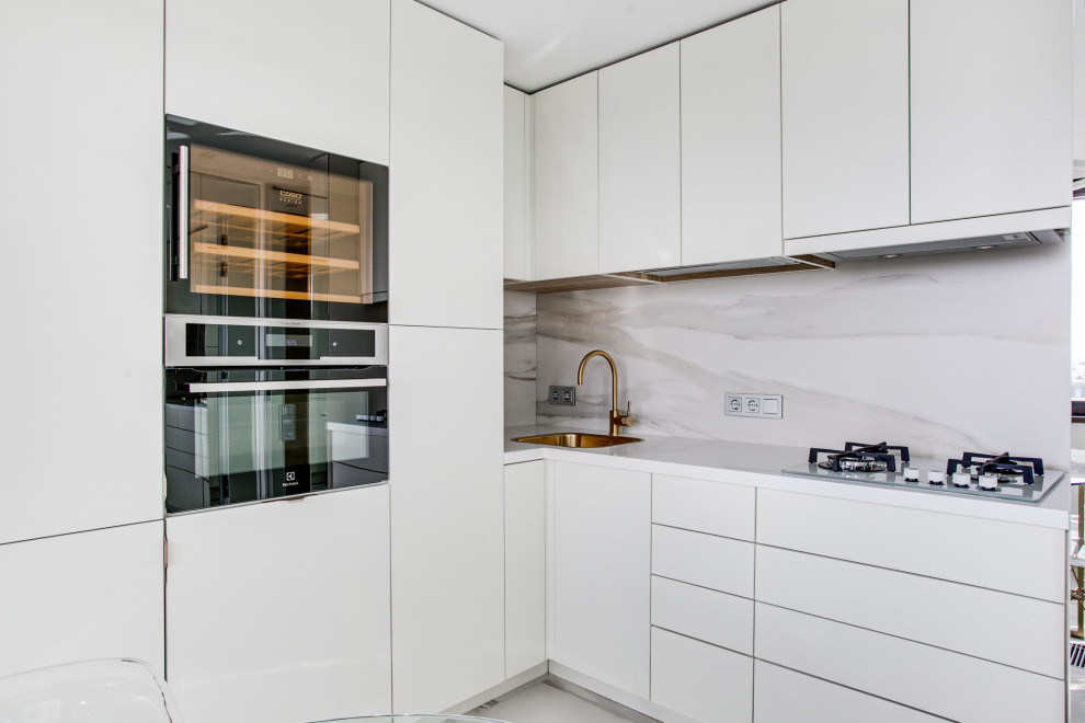 Exempel på ett stort modernt vit vitt kök, med en undermonterad diskho, släta luckor, vita skåp, granitbänkskiva, vitt stänkskydd, stänkskydd i marmor, marmorgolv, vitt golv och rostfria vitvaror