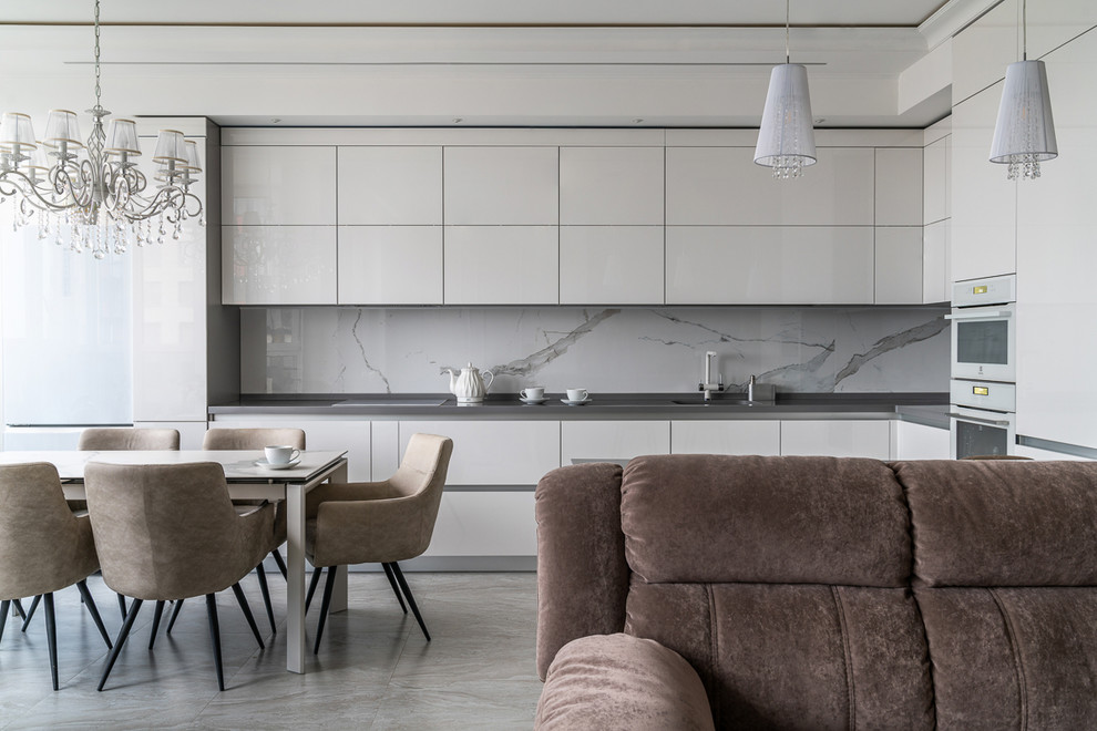 Inredning av ett modernt mellanstort grå grått kök, med en undermonterad diskho, släta luckor, beige skåp, marmorbänkskiva, beige stänkskydd, stänkskydd i stenkakel, vita vitvaror, marmorgolv och beiget golv