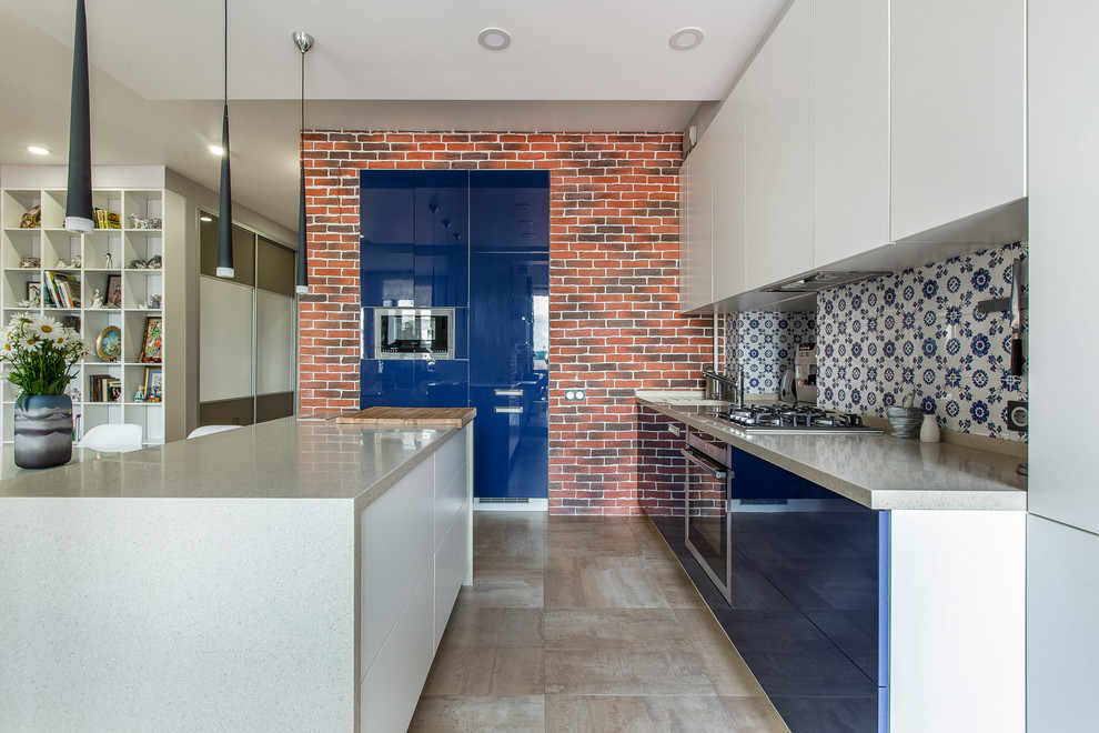 Foto di un cucina con isola centrale minimal con ante lisce, ante blu, paraspruzzi multicolore e elettrodomestici in acciaio inossidabile
