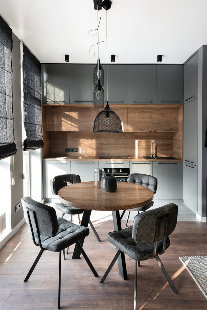 Стильный дизайн: угловая кухня в современном стиле с плоскими фасадами, серыми фасадами, коричневым фартуком и коричневой столешницей - последний тренд