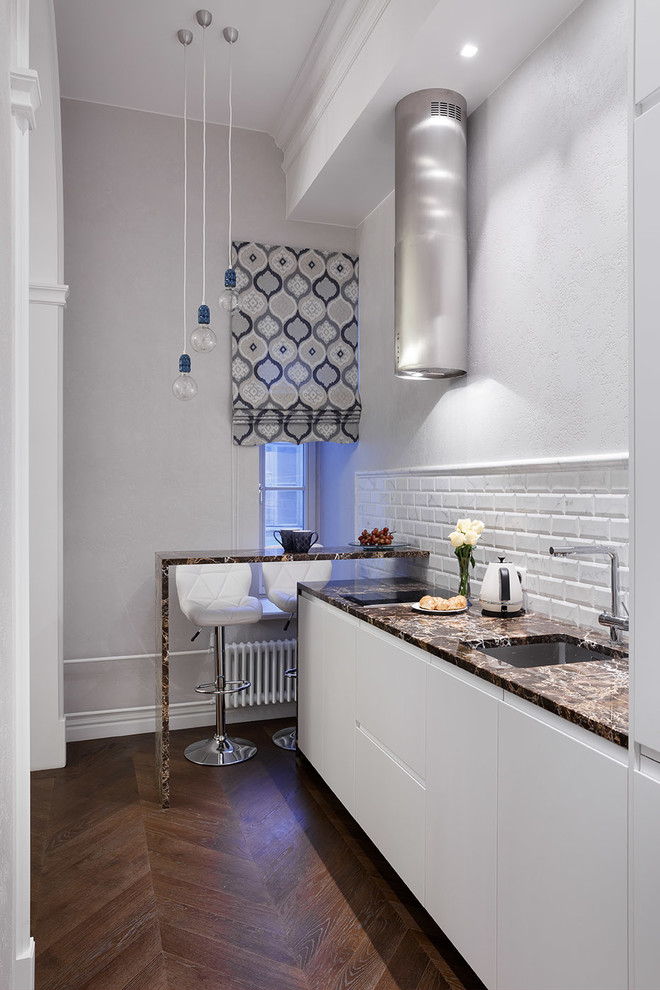 Design ideas for a small traditional single-wall enclosed kitchen in Saint Petersburg with a submerged sink, marble worktops, white splashback, dark hardwood flooring, flat-panel cabinets, white cabinets, metro tiled splashback, no island and brown floors.