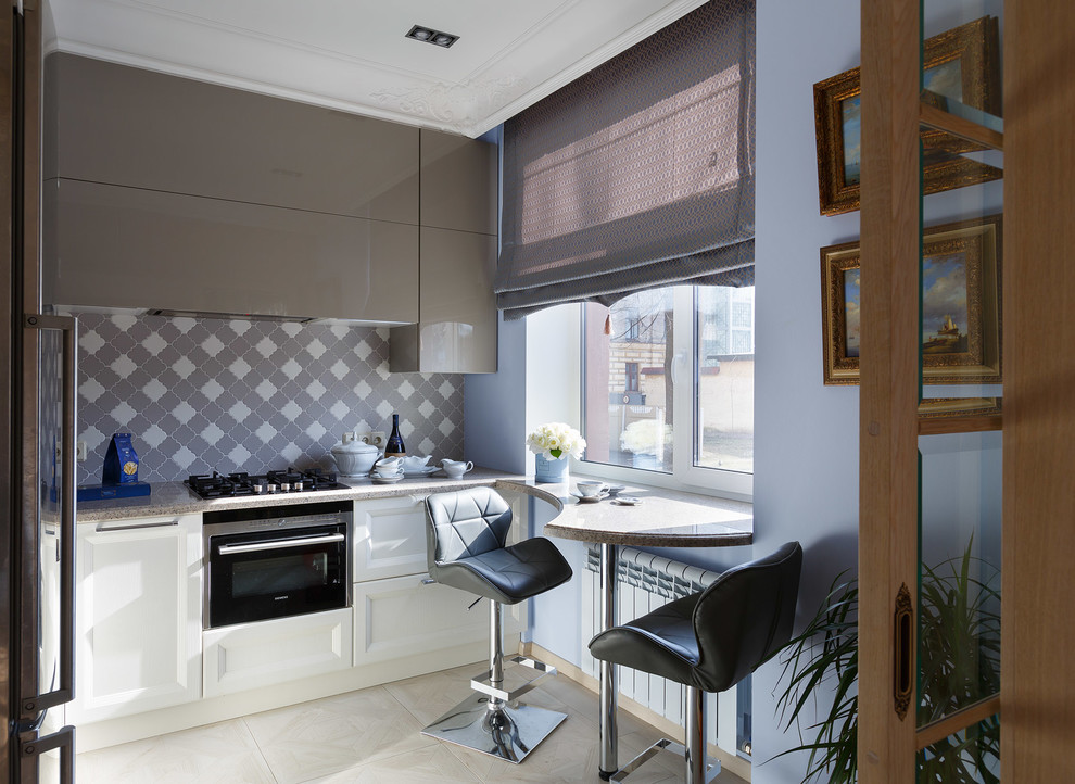 Aménagement d'une cuisine bicolore contemporaine avec une crédence grise et un électroménager noir.