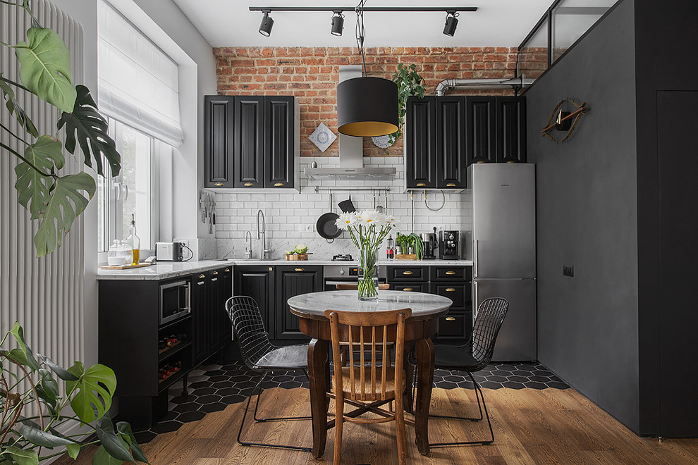 Open concept kitchen - industrial l-shaped open concept kitchen idea in Moscow with raised-panel cabinets, black cabinets, white backsplash, subway tile backsplash, stainless steel appliances and no island