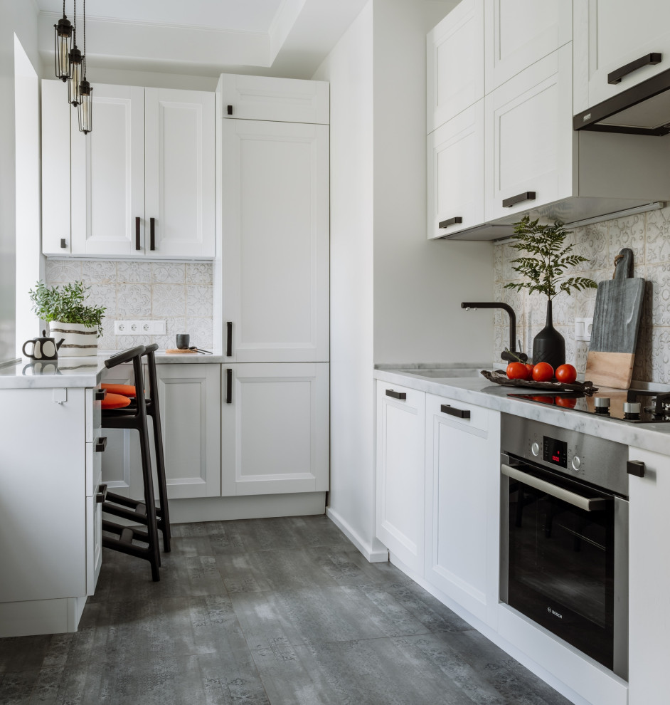 Идея дизайна: п-образная кухня в скандинавском стиле с фасадами с утопленной филенкой, техникой из нержавеющей стали, полуостровом, серым полом, серой столешницей и черно-белыми фасадами