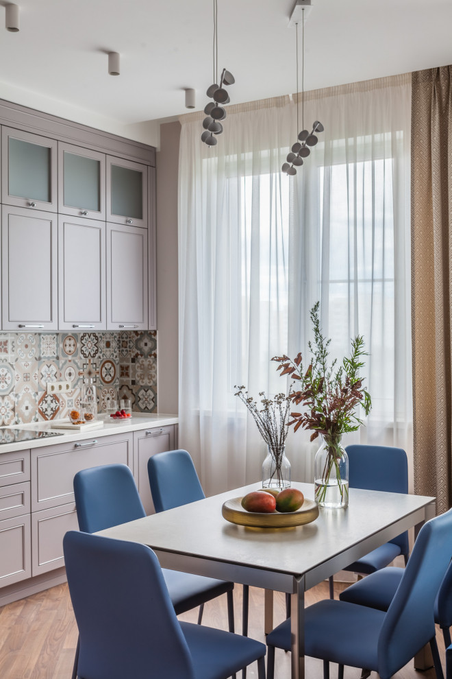 Diseño de cocina comedor clásica renovada con puertas de armario violetas, salpicadero multicolor, suelo de madera en tonos medios y encimeras blancas