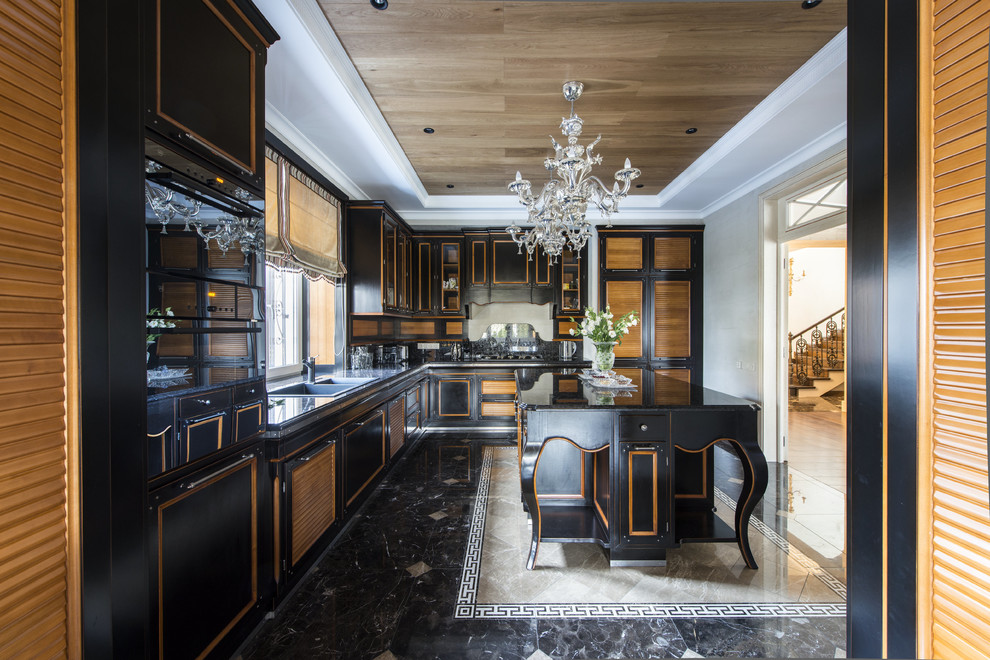 Стильный дизайн: отдельная, угловая кухня в классическом стиле с мраморным полом, островом и черными фасадами - последний тренд
