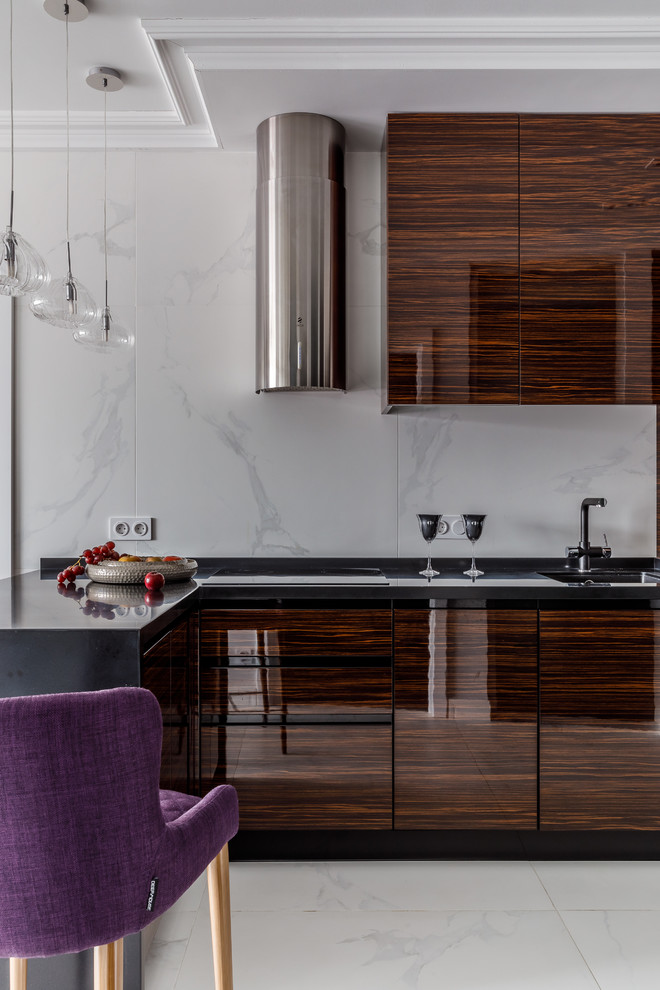 Moderne Küche mit Unterbauwaschbecken, flächenbündigen Schrankfronten, dunklen Holzschränken, Küchenrückwand in Weiß, weißem Boden und schwarzer Arbeitsplatte in Sonstige
