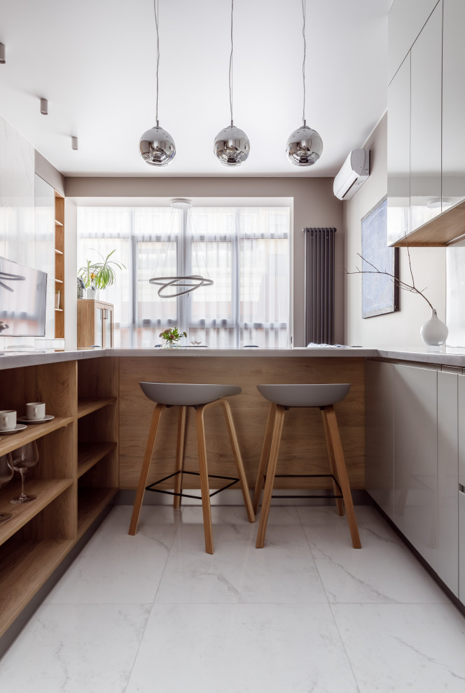 Свежая идея для дизайна: п-образная кухня-гостиная в современном стиле с плоскими фасадами, серыми фасадами, белым фартуком, полуостровом, белым полом и серой столешницей - отличное фото интерьера