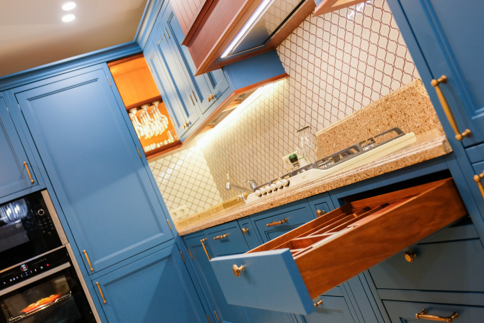 На фото: угловая кухня-гостиная среднего размера в стиле неоклассика (современная классика) с фасадами с утопленной филенкой и синими фасадами без острова