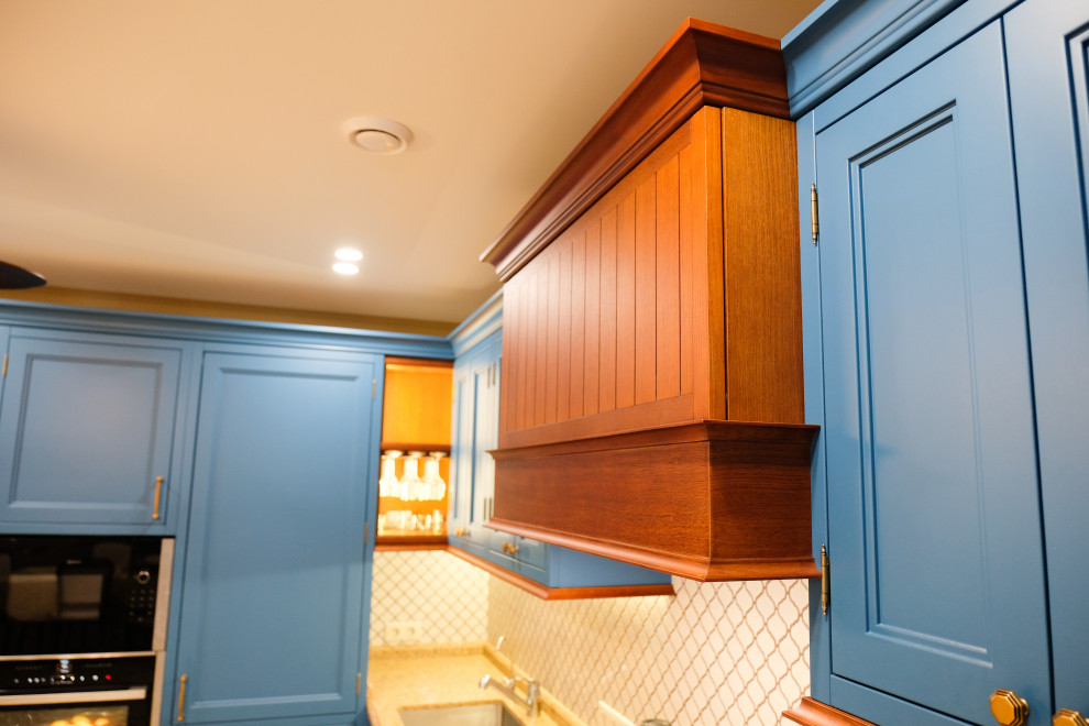 Стильный дизайн: угловая кухня-гостиная среднего размера в стиле неоклассика (современная классика) с фасадами с утопленной филенкой и синими фасадами без острова - последний тренд