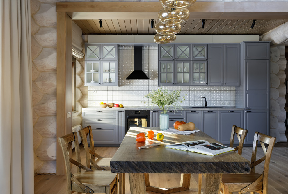 Design ideas for a large rustic single-wall kitchen/diner in Other with a submerged sink, glass-front cabinets, grey cabinets, granite worktops, white splashback, ceramic splashback, black appliances, light hardwood flooring, no island, beige floors, grey worktops and a timber clad ceiling.