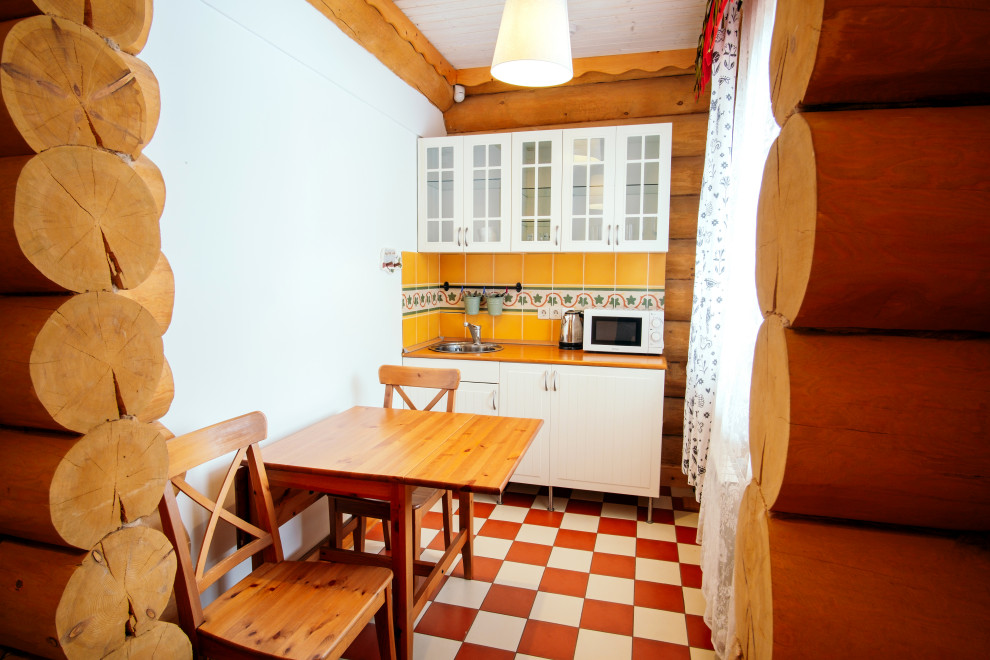 Einzeilige, Kleine Mid-Century Wohnküche mit Einbauwaschbecken, Glasfronten, weißen Schränken, Küchenrückwand in Orange, Rückwand aus Keramikfliesen, Keramikboden und oranger Arbeitsplatte in Sonstige