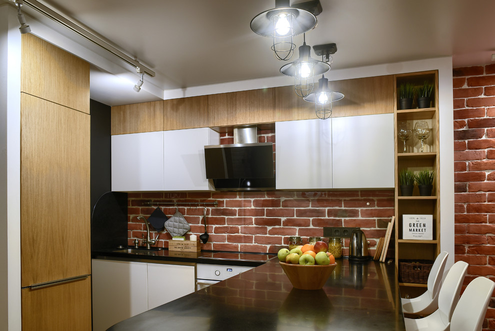 Foto på ett litet industriellt kök, med en enkel diskho, släta luckor, skåp i ljust trä, bänkskiva i koppar, rött stänkskydd, glaspanel som stänkskydd, vita vitvaror och en halv köksö