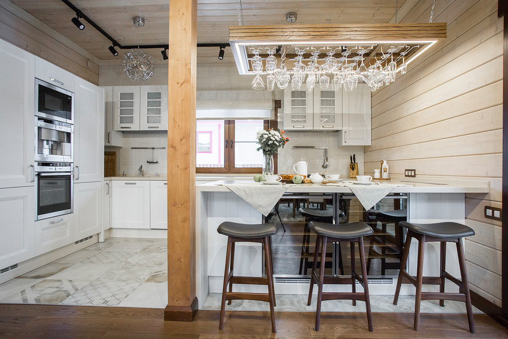 Foto di una cucina design di medie dimensioni con ante a filo, ante bianche, paraspruzzi bianco e elettrodomestici in acciaio inossidabile