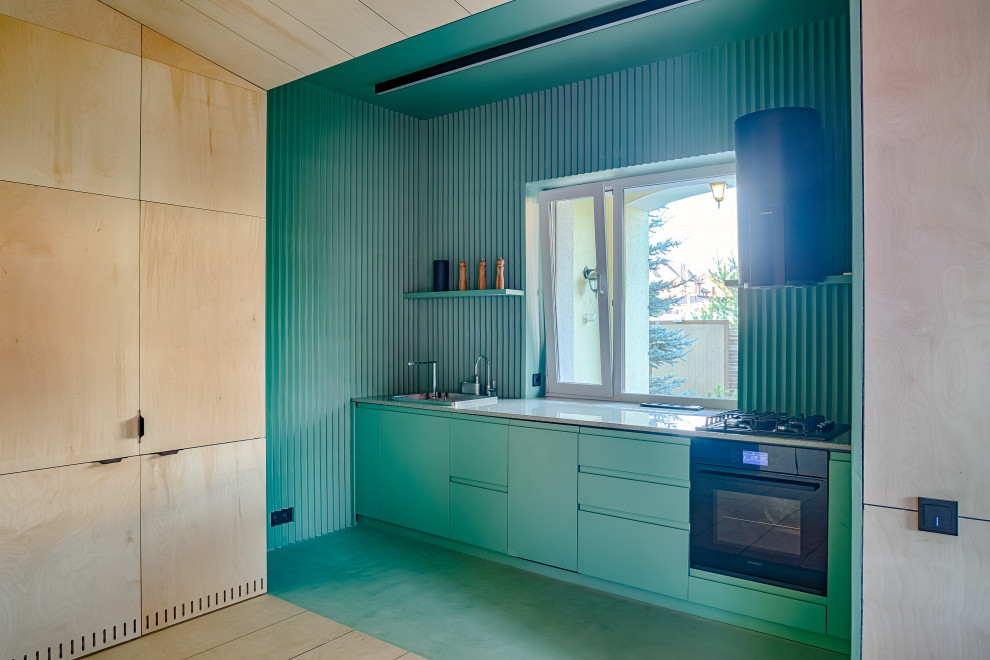 Exemple d'une cuisine linéaire tendance avec un évier posé, un placard à porte plane, des portes de placard turquoises, un électroménager noir, aucun îlot, un sol turquoise et un plan de travail gris.