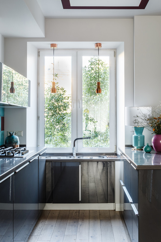 На фото: п-образная кухня в скандинавском стиле с двойной мойкой, плоскими фасадами и бежевым полом с