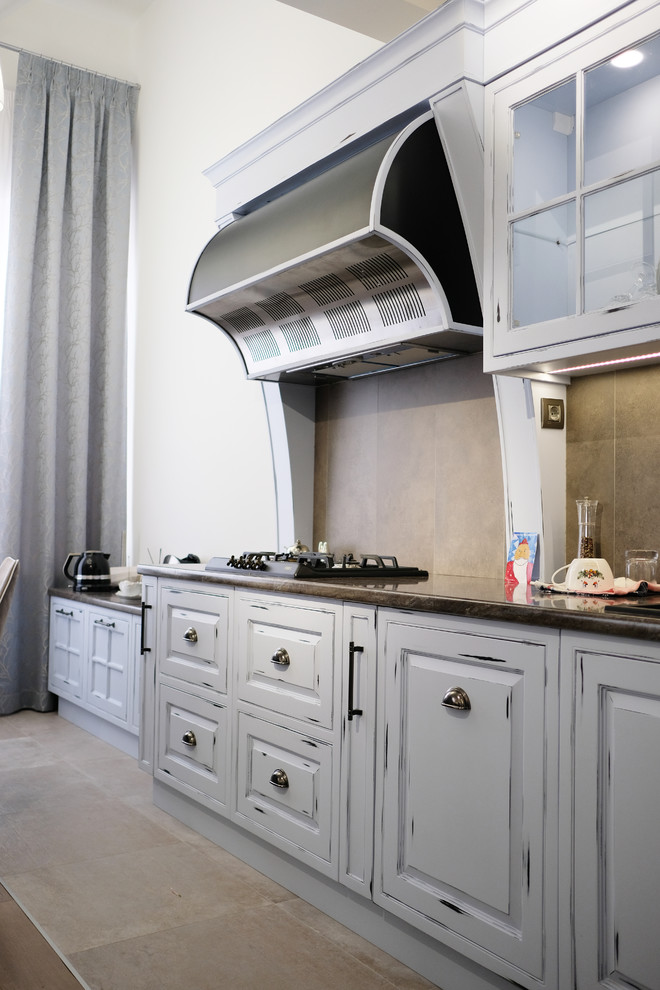 Klassisk inredning av ett stort linjärt kök med öppen planlösning, med en undermonterad diskho, skåp i shakerstil, skåp i slitet trä, träbänkskiva, svarta vitvaror, laminatgolv och en köksö