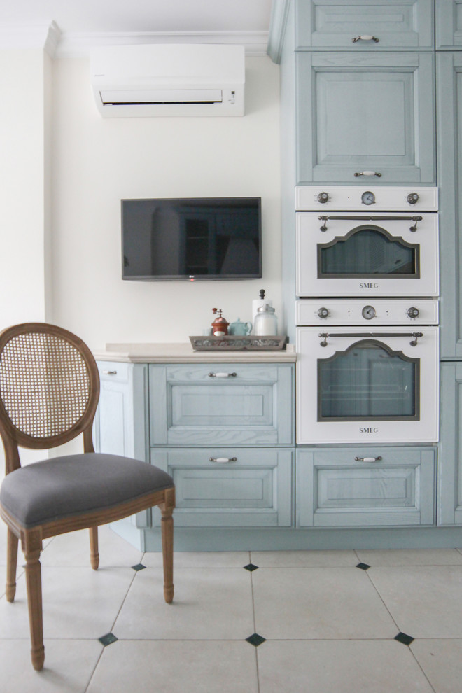 Idee per una cucina abitabile classica di medie dimensioni con ante con riquadro incassato, ante blu, top in quarzo composito, elettrodomestici bianchi e pavimento in gres porcellanato