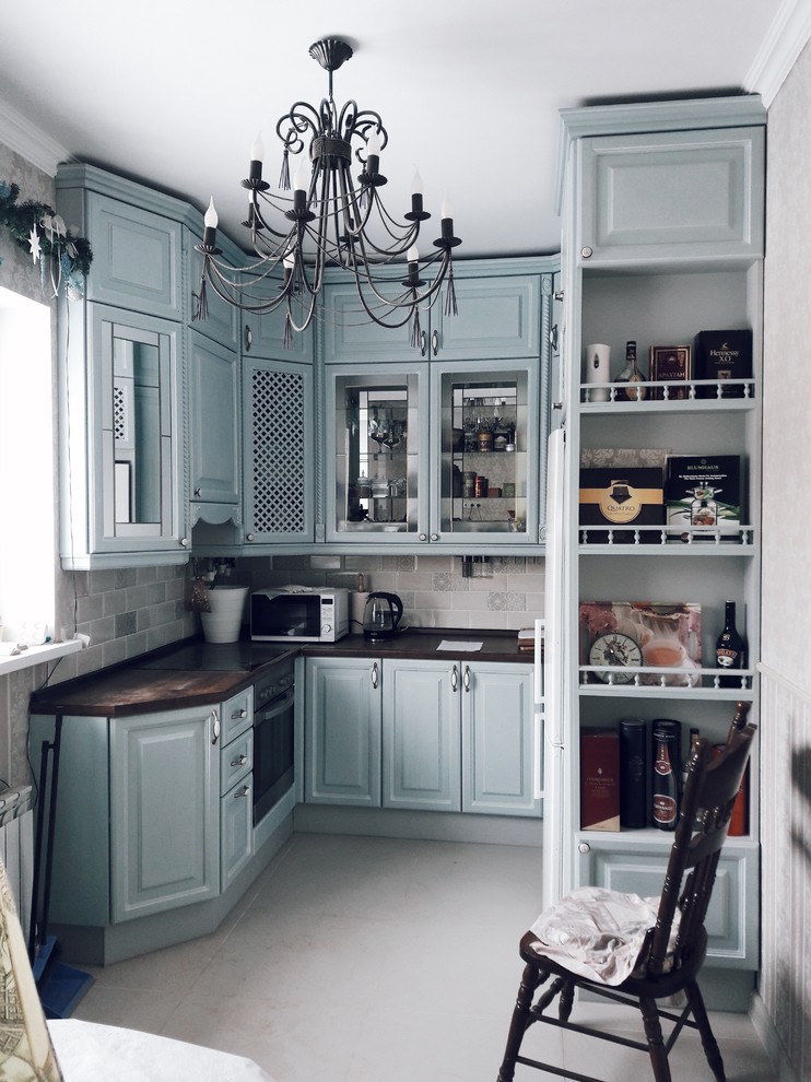 Photo of a medium sized traditional u-shaped kitchen/diner in Moscow with glass-front cabinets, grey cabinets, beige splashback, stainless steel appliances and no island.