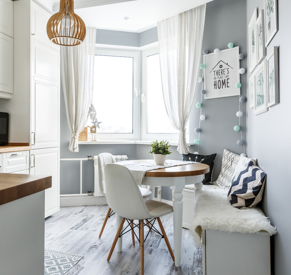 Свежая идея для дизайна: угловая, светлая кухня в скандинавском стиле с обеденным столом, светлым паркетным полом, серым полом, фасадами с выступающей филенкой, белыми фасадами и коричневой столешницей без острова - отличное фото интерьера