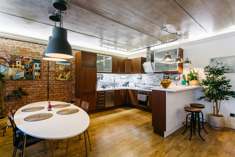 Immagine di una cucina industriale con ante in legno scuro, paraspruzzi grigio, elettrodomestici in acciaio inossidabile, pavimento in legno massello medio e penisola