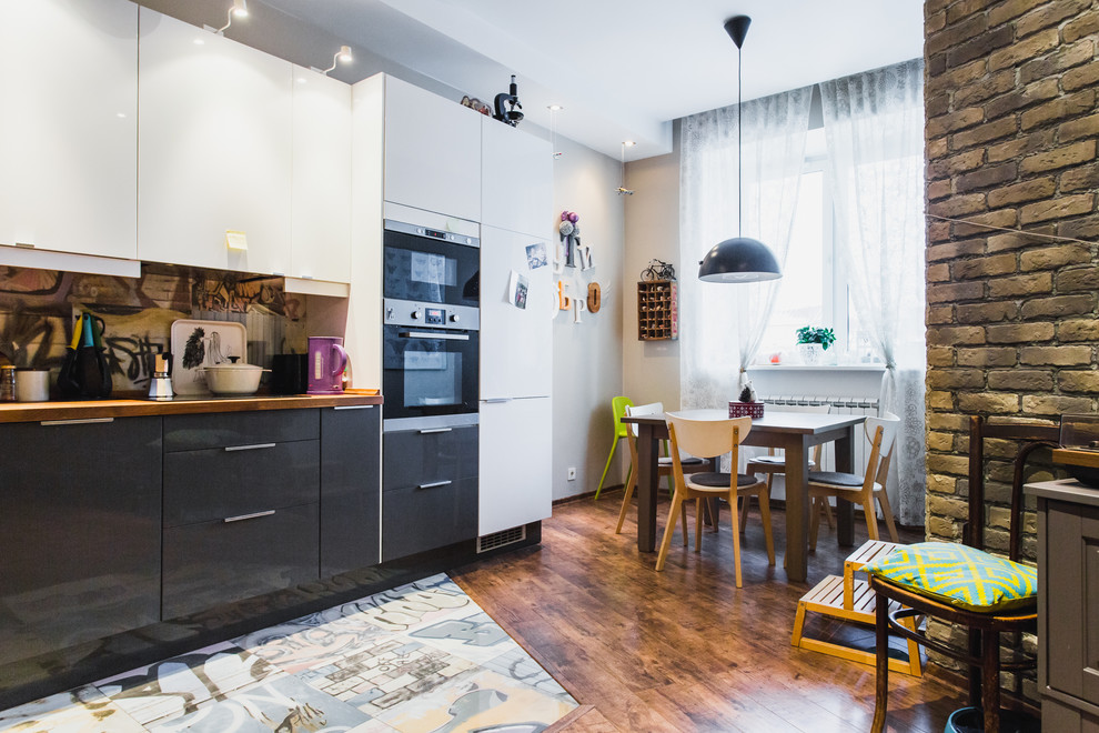 Immagine di una cucina contemporanea con ante lisce, ante nere, top in legno, paraspruzzi multicolore, elettrodomestici in acciaio inossidabile e nessuna isola