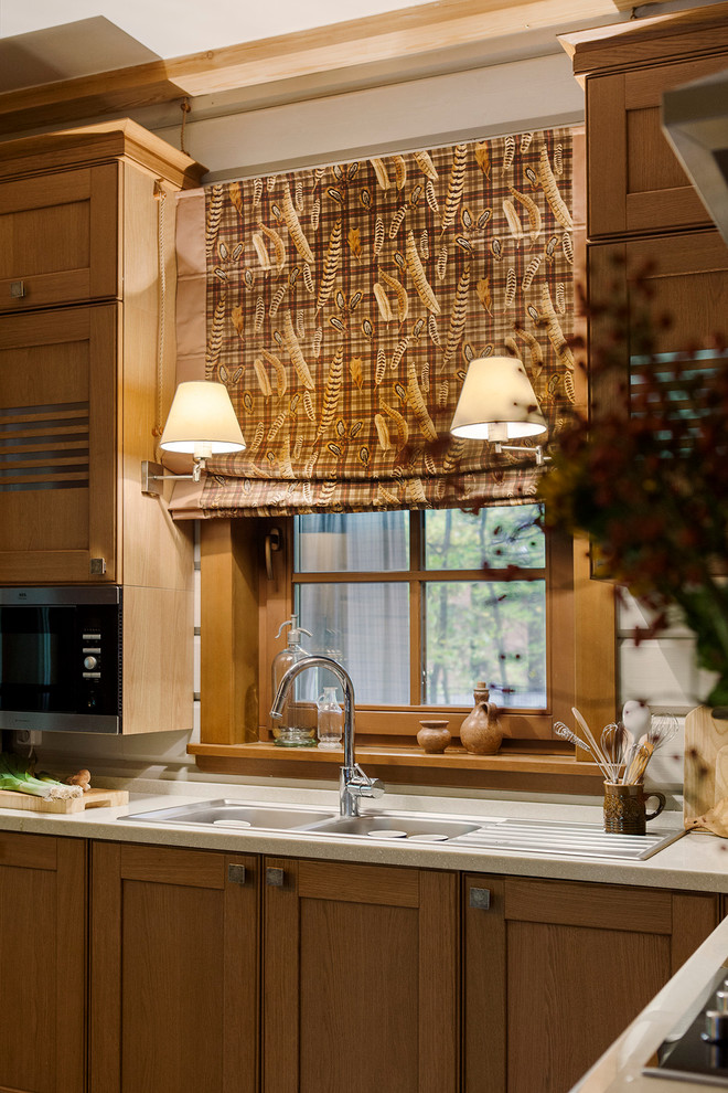 Exemple d'une cuisine nature en L et bois brun avec un évier 2 bacs, un placard à porte shaker, une crédence blanche, une crédence en feuille de verre et un électroménager en acier inoxydable.