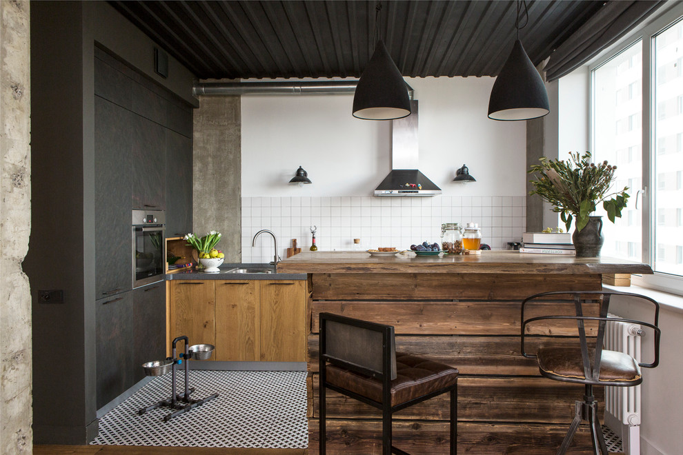 Example of an urban l-shaped open concept kitchen design in Moscow with a drop-in sink, flat-panel cabinets, medium tone wood cabinets, white backsplash, stainless steel appliances and an island