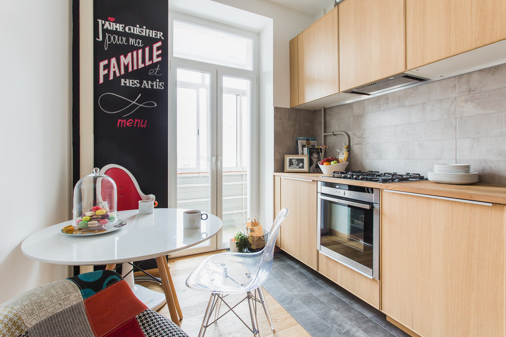 Geschlossene Moderne Küche ohne Insel in L-Form mit flächenbündigen Schrankfronten, hellen Holzschränken, Küchenrückwand in Grau und Küchengeräten aus Edelstahl in Moskau