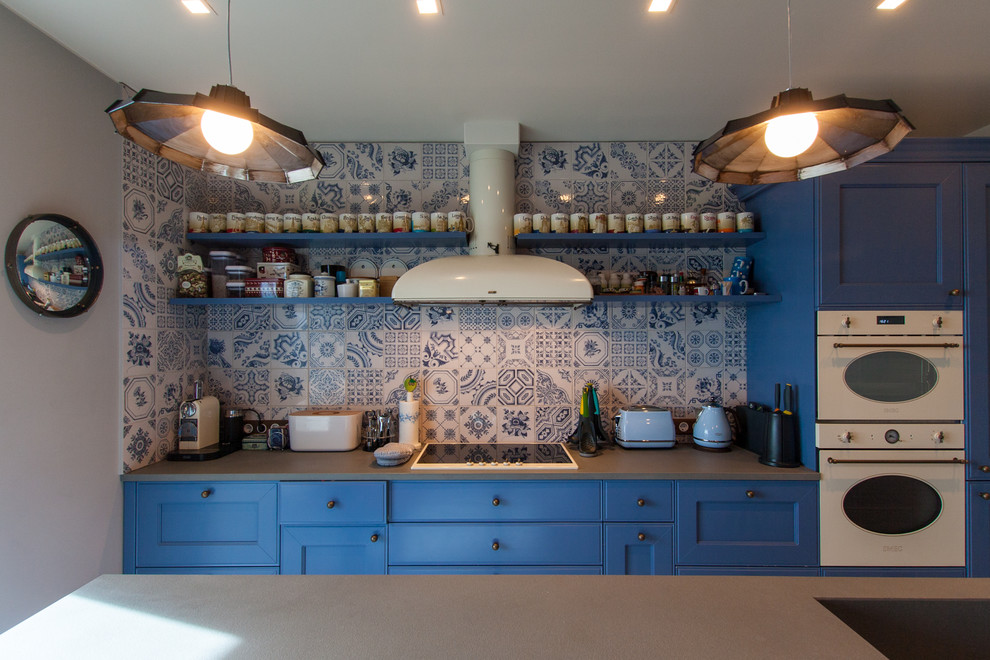 Свежая идея для дизайна: прямая кухня со стиральной машиной в стиле кантри с фасадами с утопленной филенкой, синими фасадами, разноцветным фартуком, белой техникой и островом - отличное фото интерьера