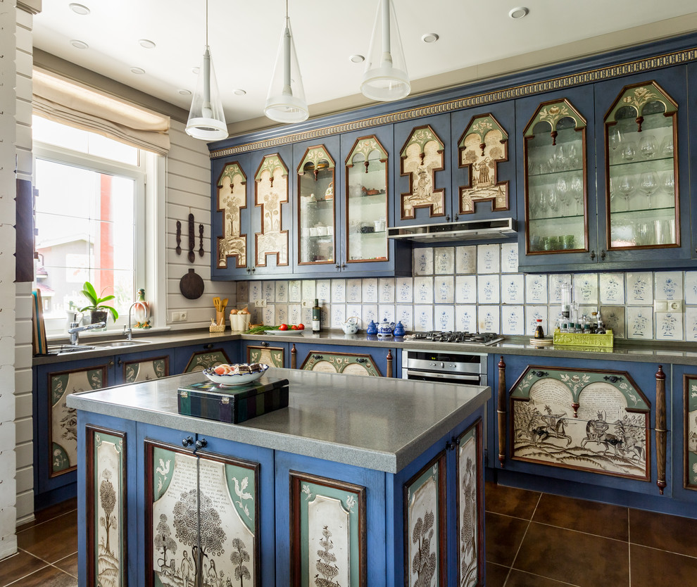 Cette image montre une cuisine américaine rustique avec un évier 2 bacs, des portes de placard bleues, une crédence blanche, un électroménager en acier inoxydable, îlot et un sol marron.