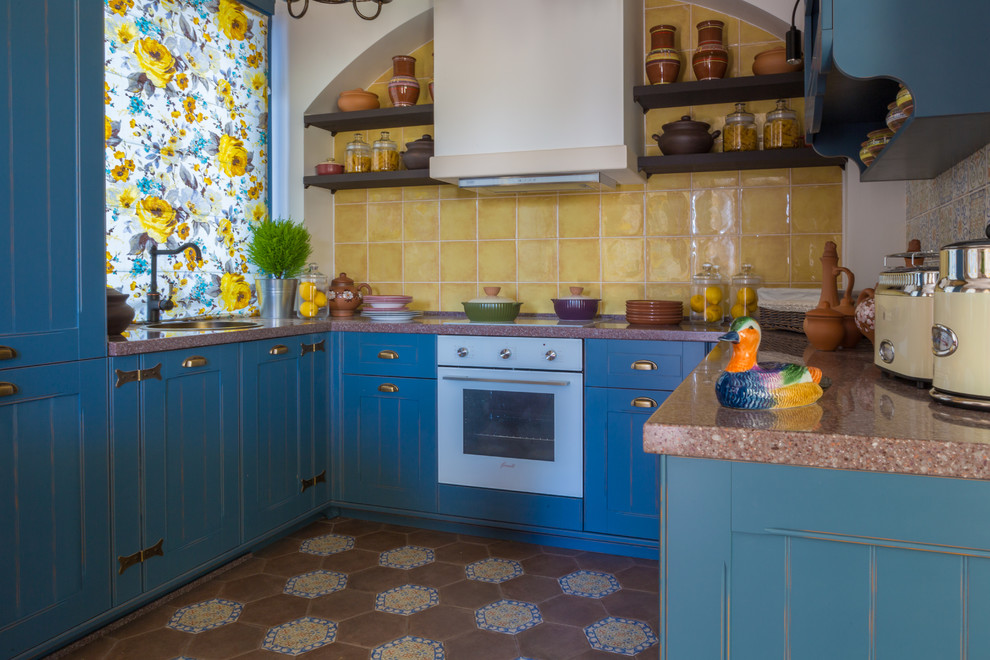 Foto di una cucina country di medie dimensioni con ante con riquadro incassato, ante blu e top in superficie solida