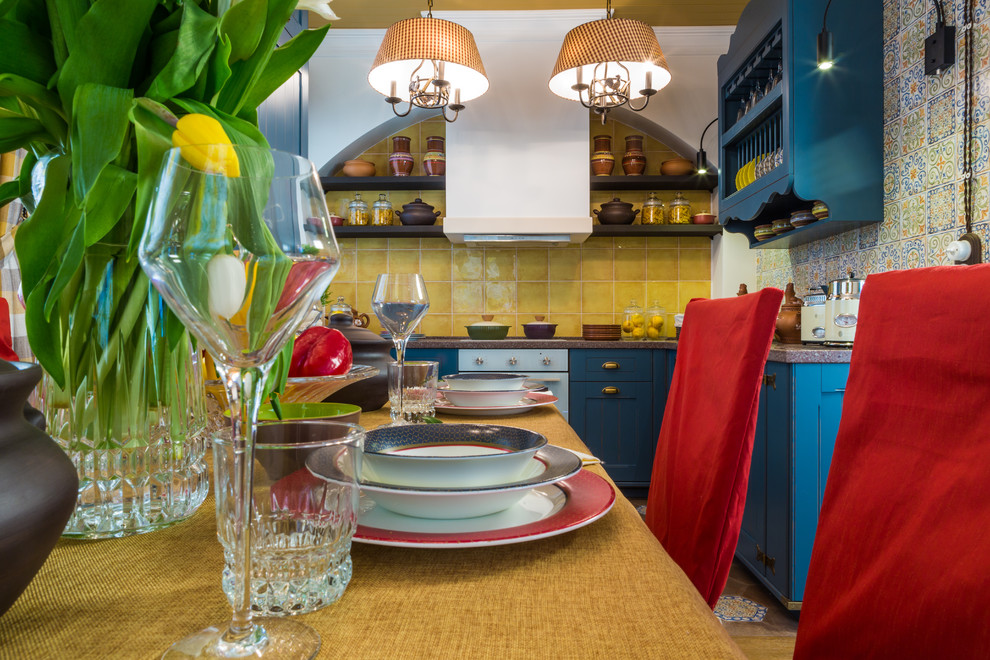 Imagen de cocina campestre de tamaño medio con armarios con paneles empotrados, puertas de armario azules y encimera de acrílico