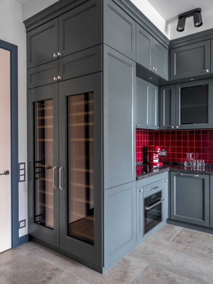 Klassisk inredning av ett mellanstort grå grått kök, med luckor med infälld panel, grå skåp, rött stänkskydd, stänkskydd i keramik, bänkskiva i kvarts, klinkergolv i porslin och beiget golv